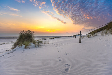 Sonnenuntergang mit schönen Wolken und Fußspuren im Sand, Nordseeinsel Amrum © MaxSch