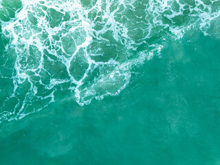 Overhead view turquoise stormy ocean waves with white foam in the ocean,Sea water with splashes and...