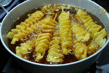 In Thailand, people like to eat crispy fried potato skewers.
