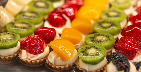 Delicious mini fruit tarts with kiwi, strawberry, peach, and more! A colorful and tempting dessert display