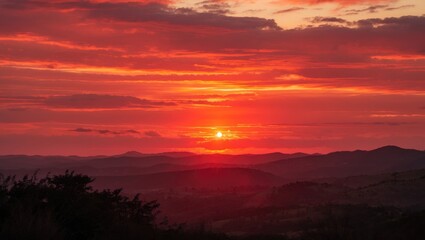 Obraz premium Vibrant Sunset with Fiery Orange and Red Sky Over Mountainous Landscape Providing Ample Space for Text and Design Elements