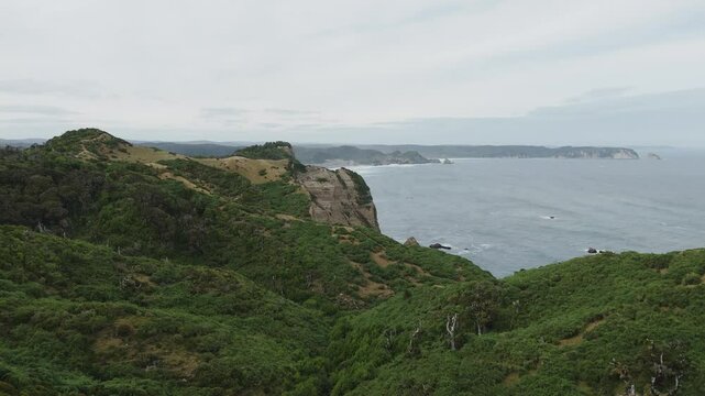 Aerial view capturing dramatic cliffs and coastline near Muelle De Las Almas, highlighting Chiloe Island's natural beauty
