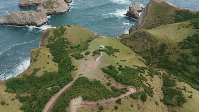 Scenic aerial view of Muelle De Las Almas amidst natural landscapes and ocean cliffs. circle dolly shot