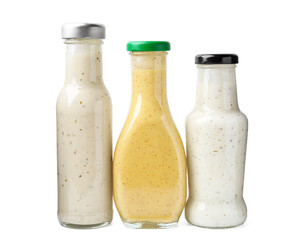 Different delicious sauces in glass bottles isolated on white