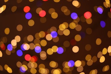 Blurred view of colorful lights on dark background, bokeh effect