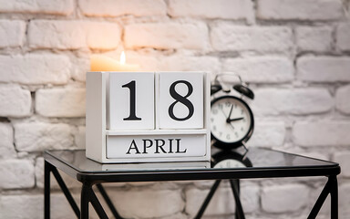 Marking a Special Day April 18 on a Stylish Wooden Calenda with Candle and Clock