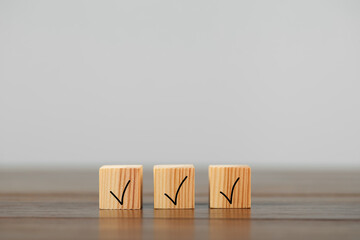 Wooden cubes with check marks on table, space for text