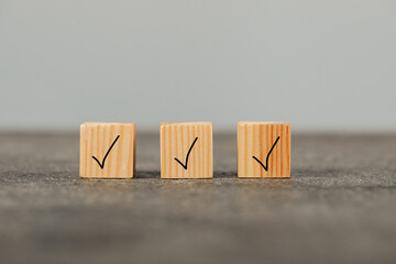 Wooden cubes with check marks on grey table
