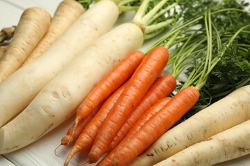 Different root vegetables on white wooden table, closeup