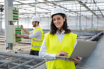 Young female engineer with a laptop checking the parameters at the construction site