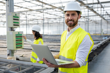Young male engineer with a laptop checking the parameters at the construction site