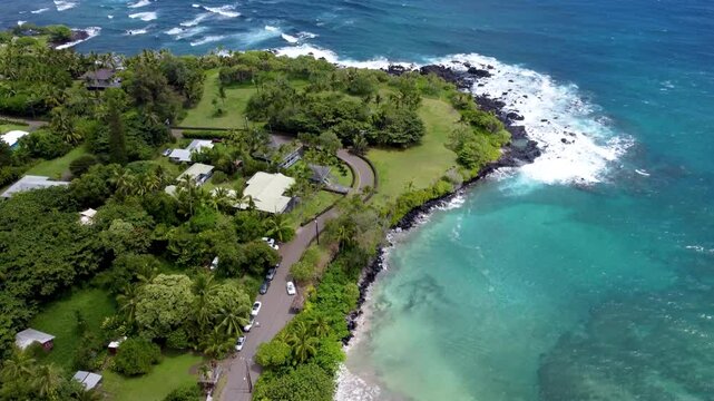 Hamoa Beach Hana Maui Hawaii &ndash; Stunning tilt-down aerial cinematic video capturing crystal-clear blue waters, powerful waves, lush green landscape, and the breathtaking tropical coastline