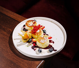 Dessert plated elegantly with fruits and berries in a cozy setting