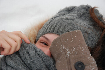 Cozy winter moment with woman in knit scarf and hat on snowy day