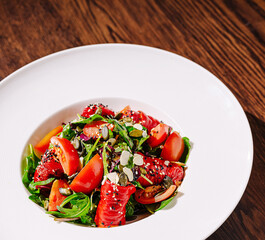 Colorful salad with vegetables and seeds on a wooden table