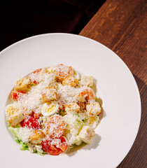 Fresh salad with crisp vegetables and cheese on a white plate