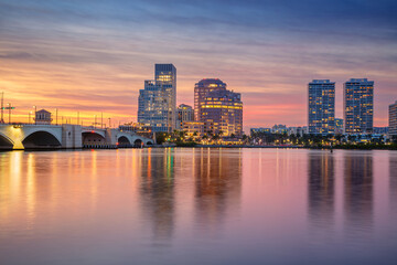 West Palm Beach, Florida, USA. Cityscape image of West Palm Beach, Florida with reflection of the city skyline in the water at beautiful sunset.