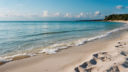 Obraz premium Tranquil Sandy Beach with Clear Turquoise Water and Serene Sky Ideal for Relaxation and Content Overlays