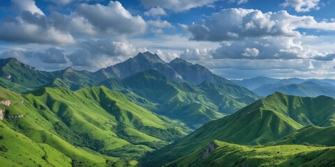 Fototapeta premium Lush Green Mountain Landscape Under a Dramatic Blue Sky with Fluffy Clouds and Distant Peaks Ideal for Nature and Travel Themes