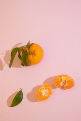 Vertical image of tangerines on a pink background with copy space. Healthy fruit rich in vitamin C