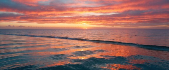 Fototapeta premium Serene Sunrise Over Ocean With Vibrant Hues Of Orange Pink And Gold Reflecting On Tranquil Waters In A Coastal Panorama.