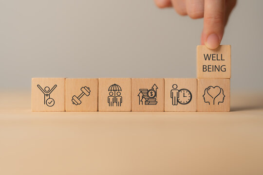 Employee wellbeing concept. Wooden blocks with physical, mental, emotional health icons. Creating employee benefits, satisfaction programs. Fostering positive work culture, employee engagement.