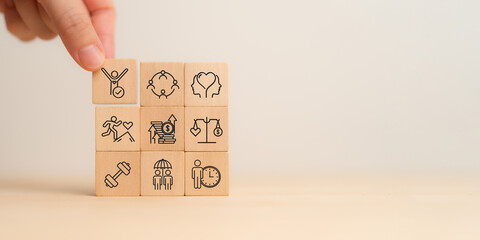 Employee wellbeing concept. Wooden blocks with physical, mental, emotional health icons. Creating employee benefits, satisfaction programs. Fostering positive work culture, employee engagement.
