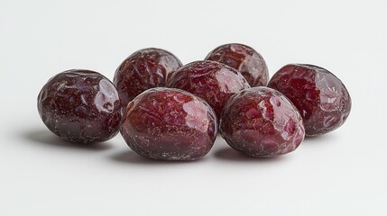 Obraz premium Close-up of a cluster of dried plums on a plain white background, showcasing texture