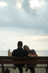 Fototapeta premium couple sitting looking at the ocean