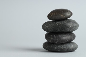Stack of rocks on gray background, space for text. Harmony and life balance