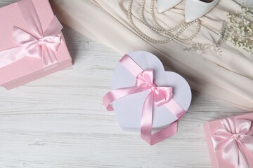 Beautiful wedding gifts, pearl jewelry, silk fabric, bridal shoes and gypsophila flowers on wooden...