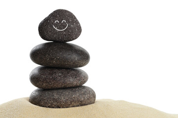 Stack of stones with drawn smiley face on sand against white background. Harmony and life balance