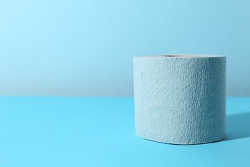 Light blue toilet paper roll on color background, closeup. Space for text