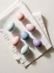 Gorgeous pastel-colored Easter eggs are arranged neatly on a simple white napkin, creating a luxurious and festive atmosphere perfect for holiday gatherings and celebrations
