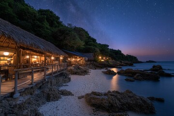 Evening seaside view of a rustic beach resort under a starry sky near calm waters