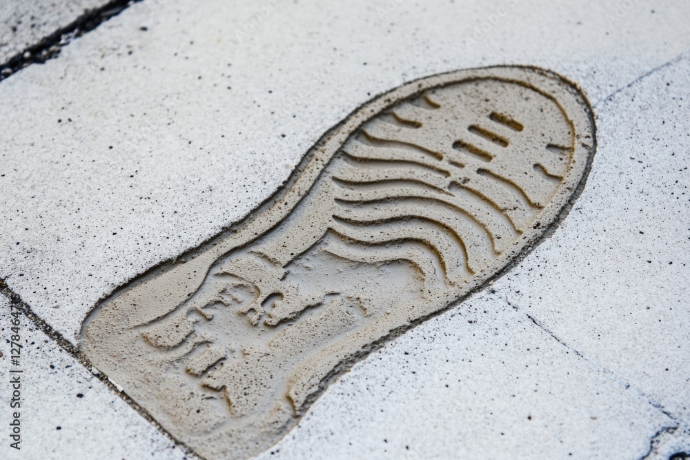 Poster a close-up of a shoe print on a concrete sidewalk, ideal for crime scene or forensic investigation u