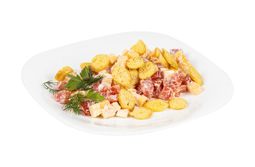 A white plate with salad and crackers on a white background