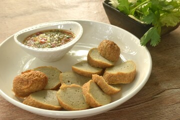 slice steamed fish line on plate dipping spicy sour chili sauce eat couple fresh vegetable