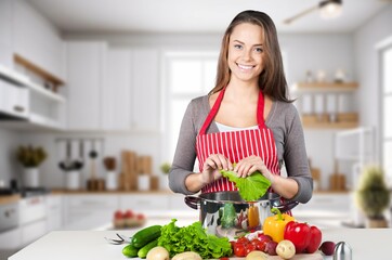 Happy young woman cooking healthy food in modern kitchen