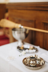 A table with the following items prepared for the sacrament of baptism: consecrated water,...