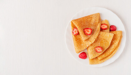 Top view of traditional homemade thin french crepe dessert or sweet blini snack decorated with red...