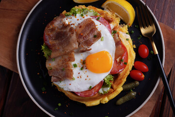 Fried Egg and Pork Waffles Food in a black plate on a wooden table