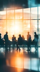 A group of business people in silhouette stand around an office table
