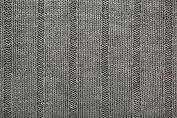 Dark gray soft knitted fabric pattern background. Closeup. Top down view.