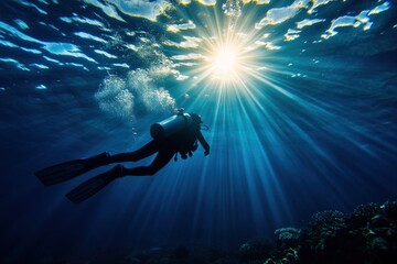 Diver ascends sunlit ocean, coral reef below