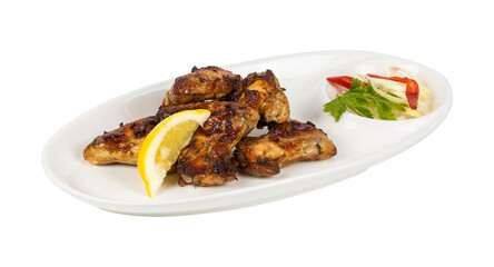 A white plate topped with chicken wings and a slice of lemon