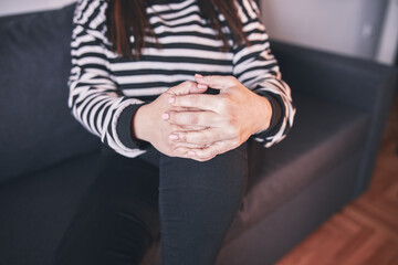 Woman with painful knee and leg injury at home.