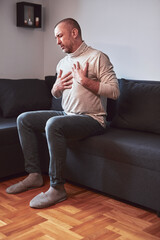 Fototapeta premium Man with gastritis, chest and abdominal pain at home.