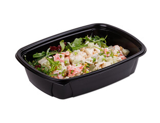 A fresh salad presented in a black plastic container atop a white background