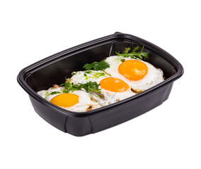 Fried eggs in a black container on a clean white background